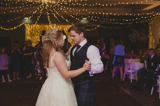 Bride and groom's first dance at Norwood Hall Hotel with fairy lights draped on ceiling in background